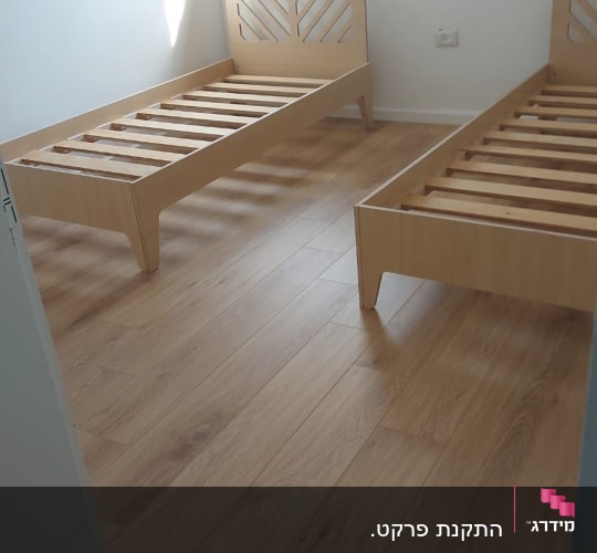 רצפת פרקט עץ בחדר שינה עם מיטות עץ